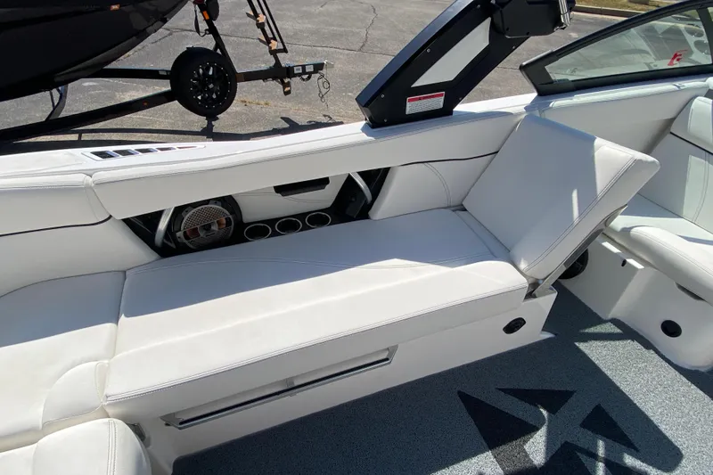 Slide: The Image of 2022 MasterCraft XT25 boat interior with white seating and speaker system. - 19