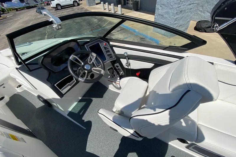 Slide: The Image of 2022 MasterCraft XT25 boat interior with steering wheel and white seating. - 25
