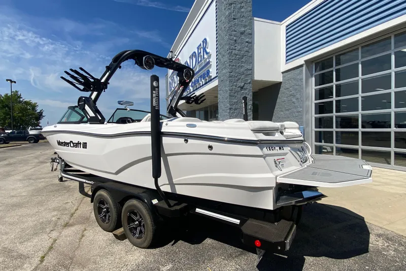 Slide: The Image of 2022 MasterCraft XT25 boat on trailer outside dealership, showcasing sleek design and features. - 3