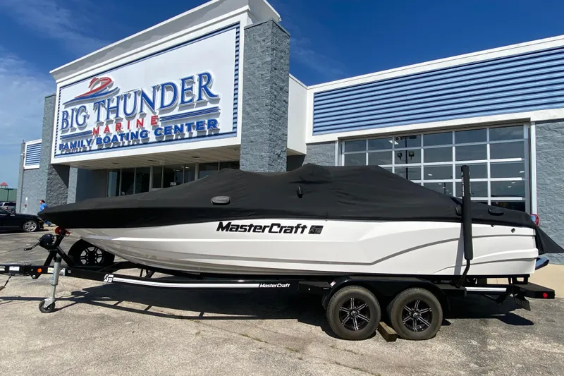 Slide: The Image of 2022 MasterCraft XT25 boat covered, parked at Big Thunder Marine dealership. - 41