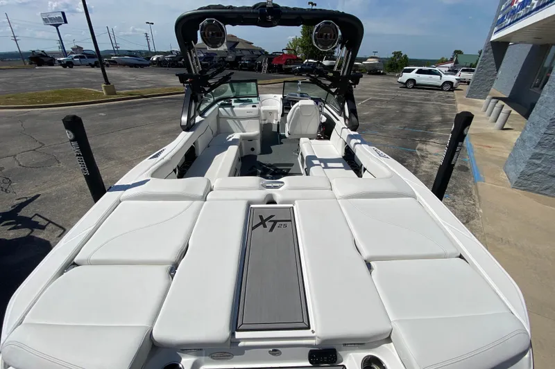 Slide: The Image of 2022 MasterCraft XT25 boat with white interior, parked outdoors. - 8
