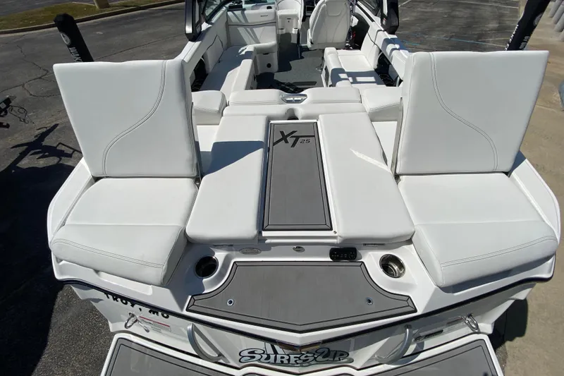 Slide: The Image of 2022 MasterCraft XT25 boat interior with white seating and "Surf's Up" logo. - 9