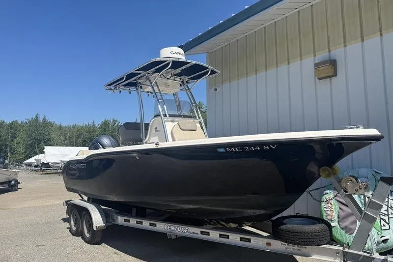 The Image of 2021 Key West 219 FS boat on trailer, parked outdoors near a building. - 2