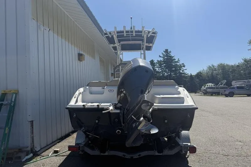 Slide: The Image of 2021 Key West 219 FS boat with outboard motor, parked outdoors. - 5