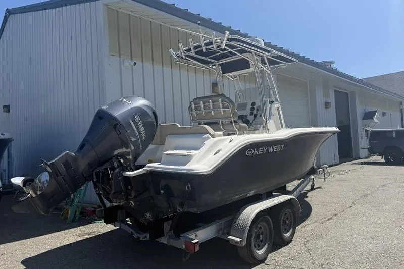 Slide: The Image of 2021 Key West 219 FS boat on trailer, parked outside a white building. - 6