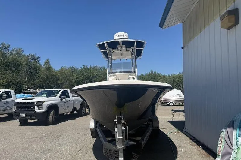 Slide: The Image of 2021 Key West 219 FS boat on trailer, parked near trucks and building. - 9