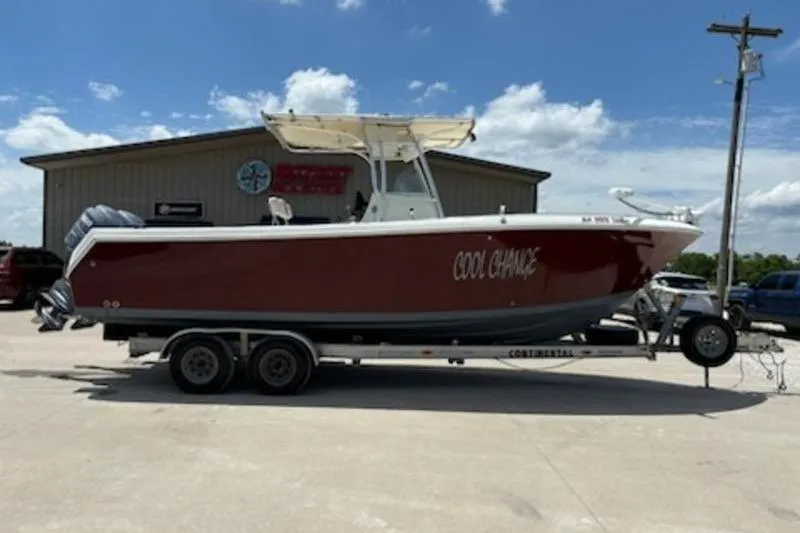 The Image of 2006 Sailfish 2660 CC boat on trailer with Yamaha engine, parked on grass under clear blue sky. - 1