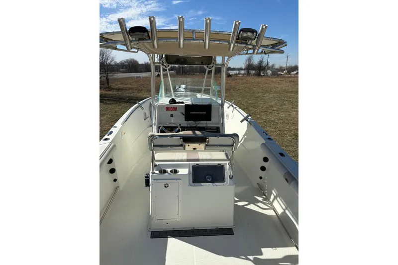 Slide: The Image of 2006 Sailfish 2660 CC boat interior with console and seating, under clear blue sky. - 13