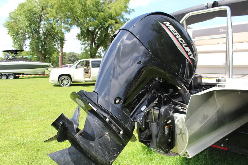 Slide: The Image of 2024 Barletta Aria 24UC with Mercury outboard engine on grassy field. - 11