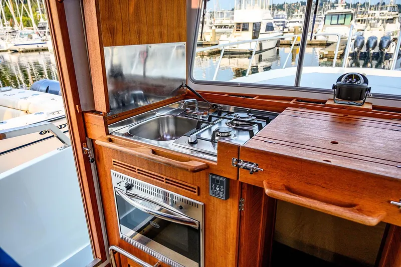 Slide: The Image of Compact kitchen area on a 2019 Targa 35 boat, featuring a stove and sink. - 18