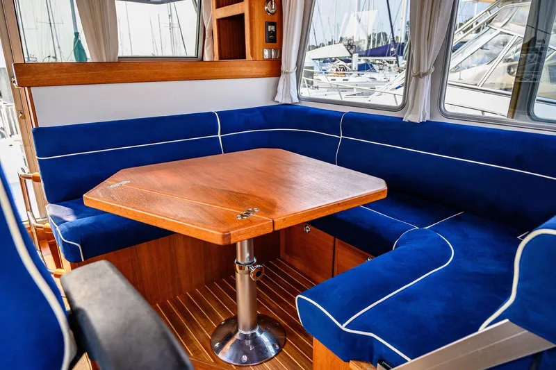 Slide: The Image of Interior of 2019 Targa 35 boat with blue cushioned seating and wooden table. - 28