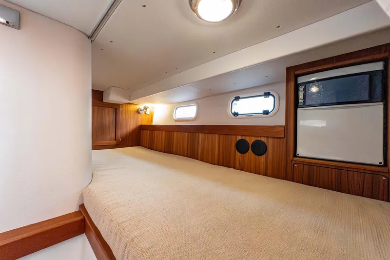 Slide: The Image of 2019 Targa 35 cabin interior with wood paneling and cozy bed. - 44