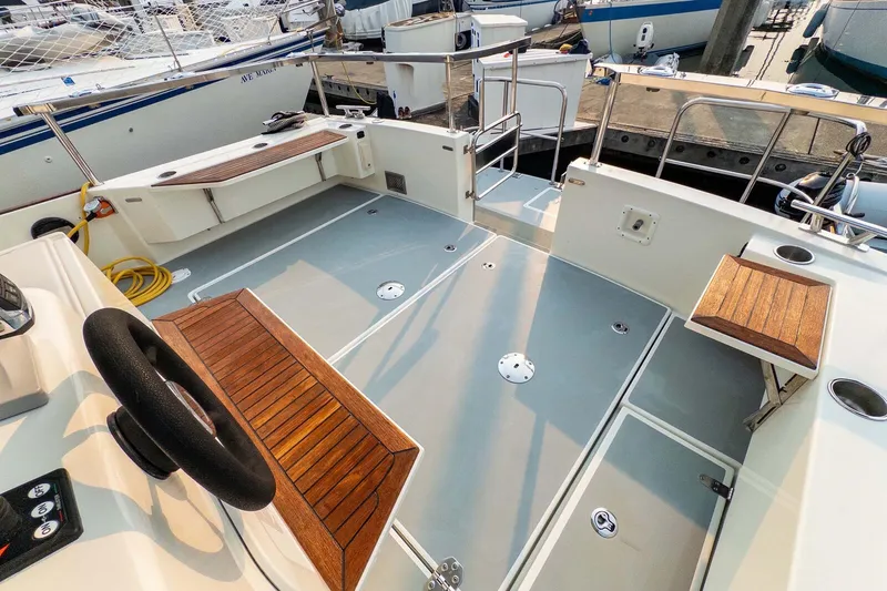 Slide: The Image of 2019 Targa 35 boat deck with wooden seating and steering wheel, docked at marina. - 50