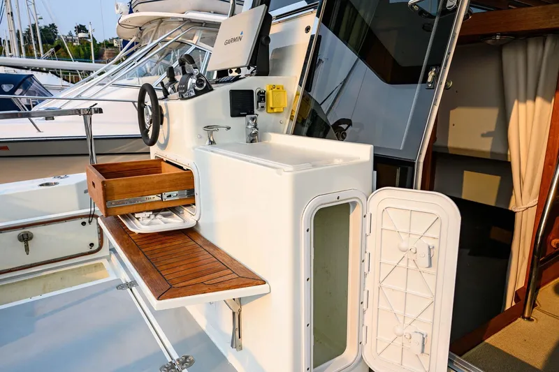 Slide: The Image of 2019 Targa 35 boat interior with wooden drawer, steering wheel, and Garmin navigation system. - 52