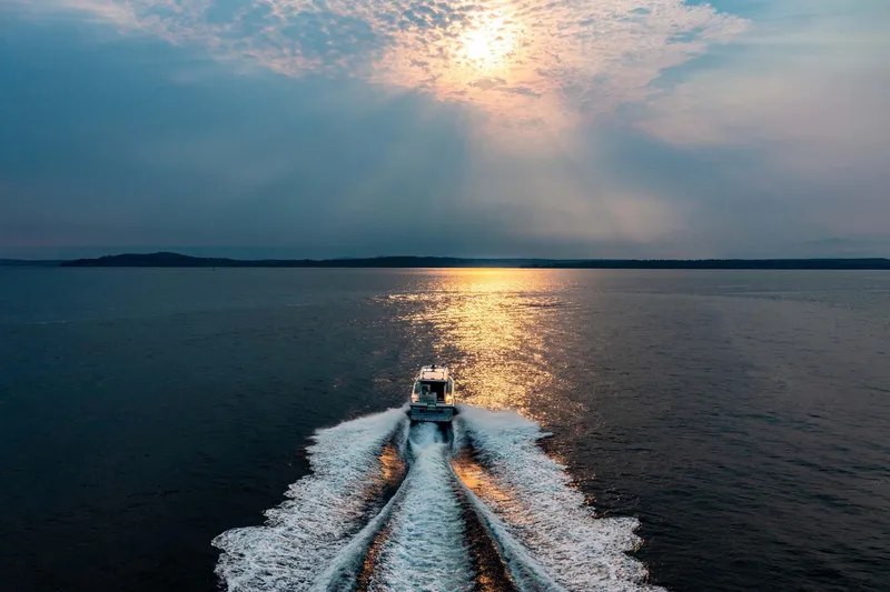 Slide: The Image of 2019 Targa 35 boat cruising at sunset on open water. - 7
