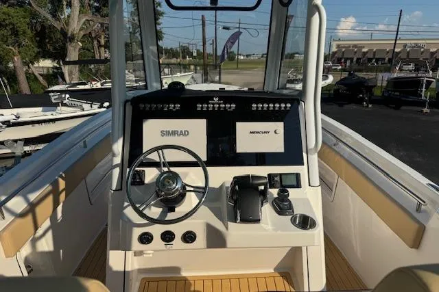 Slide: The Image of 2025 Drakkar 280CC boat cockpit with steering wheel, Simrad and Mercury displays. - 16