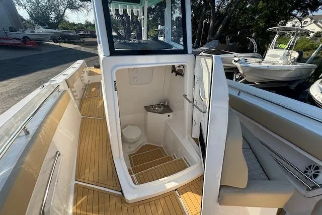 Slide: The Image of 2025 Drakkar 280CC boat interior with wooden flooring and compact bathroom. - 20