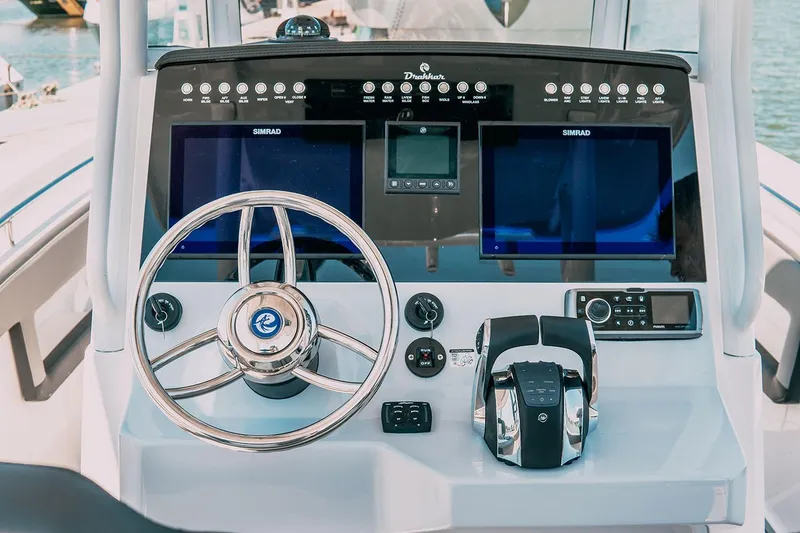 Slide: The Image of 2025 Drakkar 280CC boat dashboard with steering wheel and advanced navigation displays. - 28