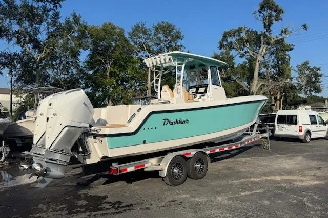 Slide: The Image of 2025 Drakkar 280CC boat on trailer, parked outdoors, with trees in the background. - 3