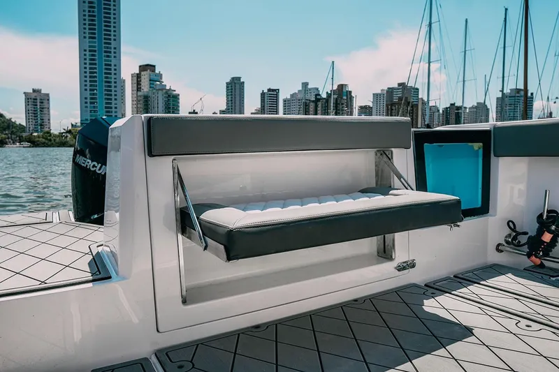 Slide: The Image of 2025 Drakkar 280CC boat interior with foldable seat, city skyline in background. - 30