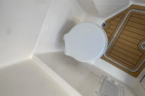 Slide: The Image of Interior of 2025 Drakkar 280CC boat featuring a compact marine toilet. - 37