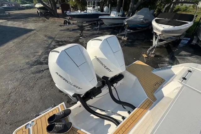 Slide: The Image of Twin Mercury engines on a 2025 Drakkar 280CC boat, docked with other vessels. - 7