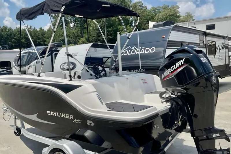 Slide: The Image of 2024 Bayliner M15 boat with Mercury engine, parked near RVs under a clear sky. - 3