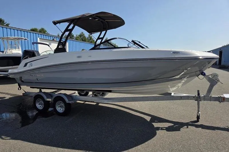 Slide: The Image of 2025 Bayliner VR6 OB boat on trailer, parked outdoors under clear sky. - 1