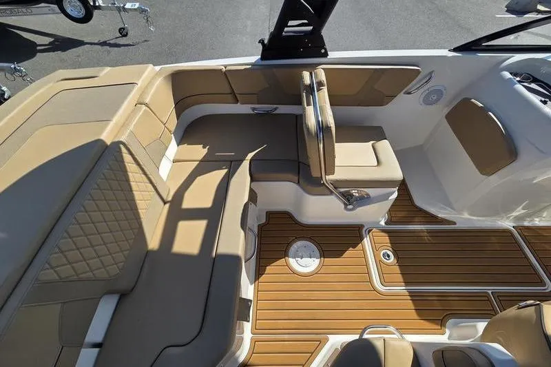 Slide: The Image of 2025 Bayliner VR6 OB boat interior with tan seating and wood-style flooring. - 2