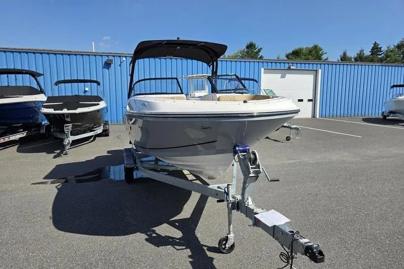 Slide: The Image of 2025 Bayliner VR6 OB boat on trailer, parked outdoors near blue building. - 3