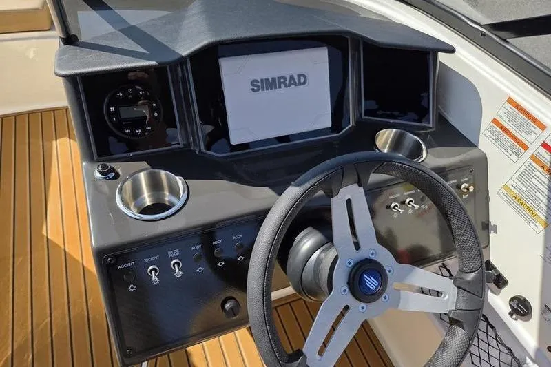 Slide: The Image of 2025 Bayliner VR6 OB boat dashboard with Simrad display and steering wheel. - 6