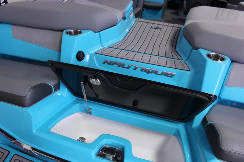 Slide: The Image of 2023 Nautique G25 boat interior with open storage compartment, blue and gray seating. - 4