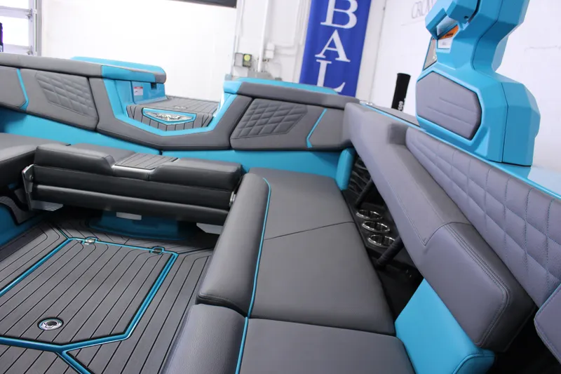 Slide: The Image of 2023 Nautique G25 interior with blue and gray seating, modern design, and cup holders. - 9