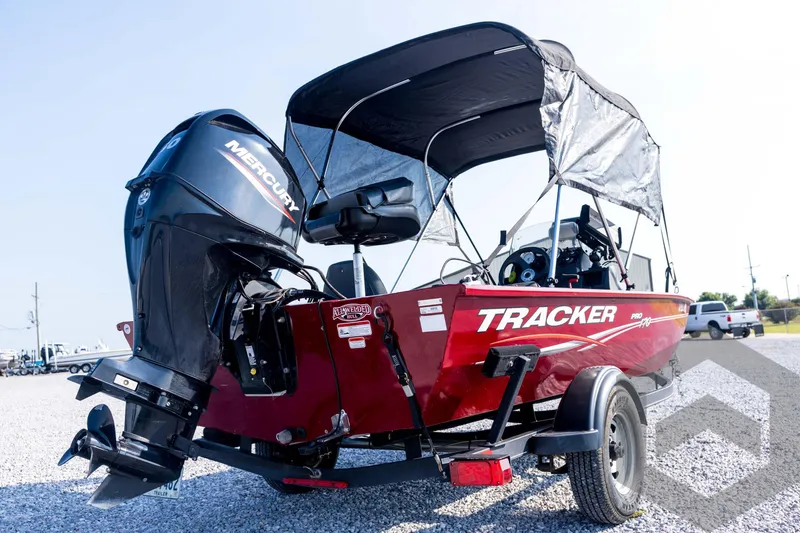 Slide: The Image of 2022 Tracker Pro 170 boat with Mercury engine, red exterior, parked on gravel. - 12