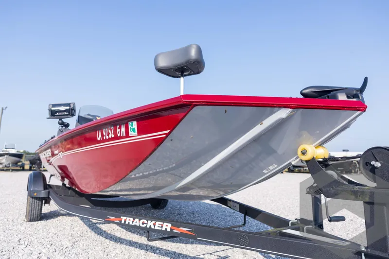 Slide: The Image of 2022 Tracker Pro 170 boat on trailer, red hull, parked on gravel. - 14