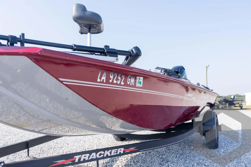 Slide: The Image of 2022 Tracker Pro 170 boat on trailer, red exterior, parked on gravel. - 31
