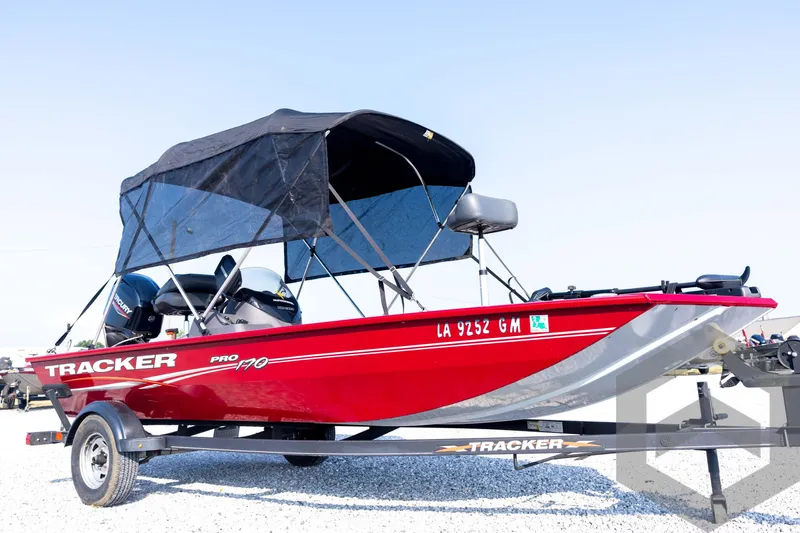 Slide: The Image of 2022 Tracker Pro 170 boat with canopy on trailer, red exterior, parked on gravel. - 9