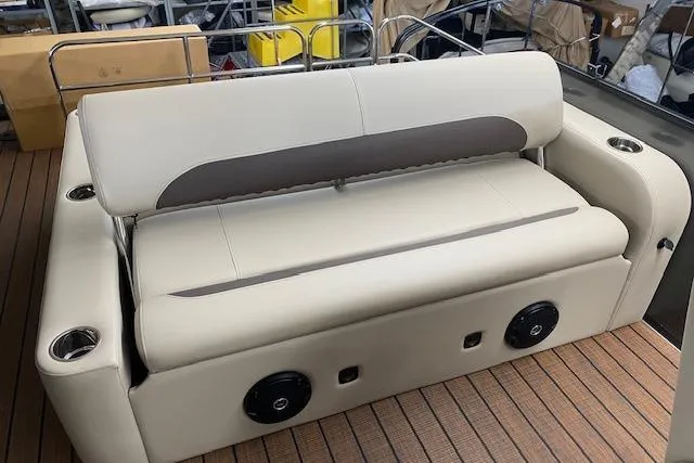 Slide: The Image of 2025 Bentley Pontoons Legacy 223 Swingback seating, beige upholstery, cup holders, and speakers. - 5