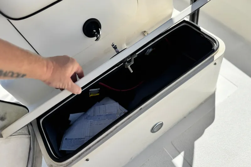 Slide: The Image of Open storage compartment on 2019 Thresher 19 CC boat with documents inside. - 12