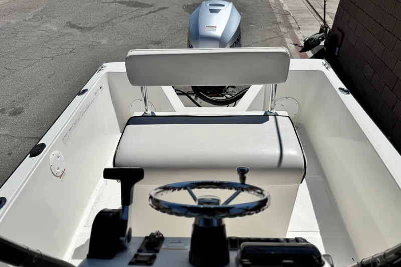 Slide: The Image of 2019 Thresher 19 CC boat interior with steering wheel and outboard motor. - 13