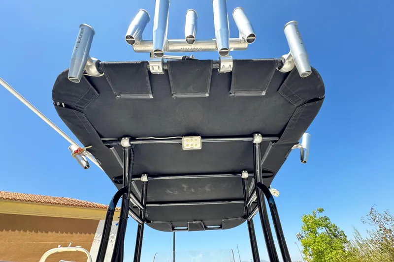 Slide: The Image of 2019 Thresher 19 CC boat T-top with rod holders against clear blue sky. - 18
