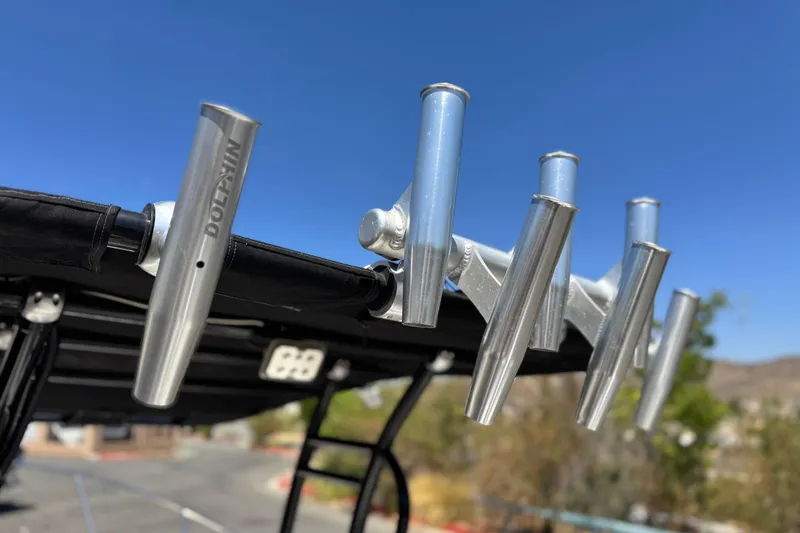 Slide: The Image of Rod holders on a 2019 Thresher 19 CC boat against a clear blue sky. - 19