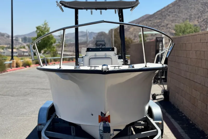 Slide: The Image of 2019 Thresher 19 CC boat on trailer, parked outdoors with scenic mountain backdrop. - 2