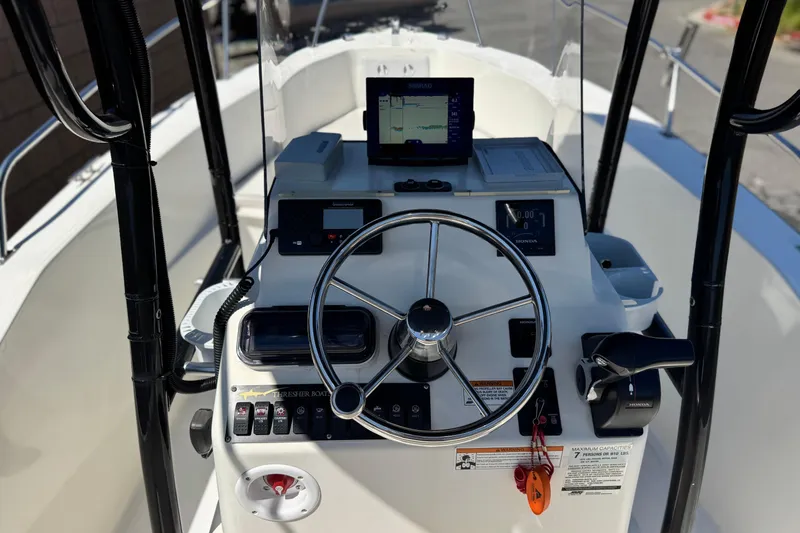 Slide: The Image of 2019 Thresher 19 CC boat dashboard with steering wheel and navigation equipment. - 21