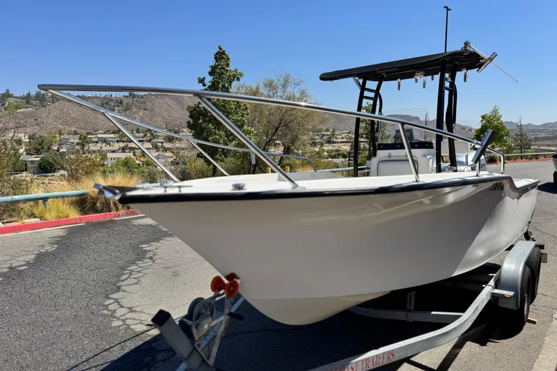 Slide: The Image of 2019 Thresher 19 CC boat on trailer, parked outdoors under clear blue sky. - 3