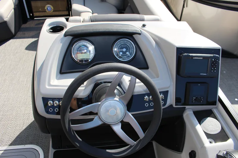 Slide: The Image of 2025 Barletta Cabrio 22CC boat dashboard with steering wheel and navigation controls. - 4