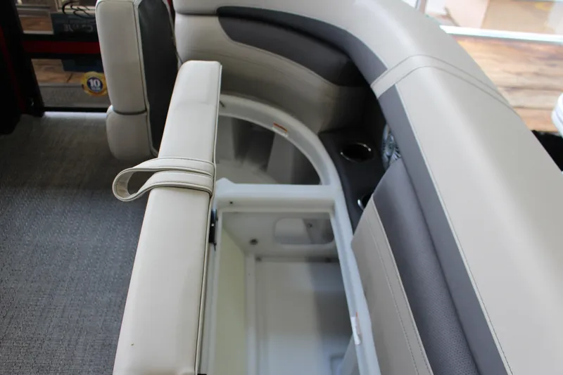 Slide: The Image of 2025 Barletta Cabrio 24UE boat interior with open storage compartment and cushioned seating. - 7