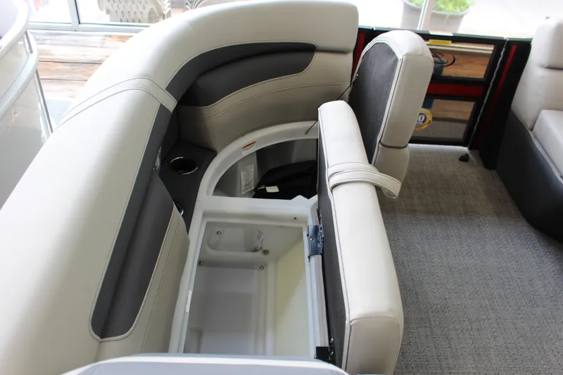 Slide: The Image of 2025 Barletta Cabrio 24UE boat interior with open storage compartment and cushioned seating. - 8