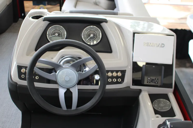 Slide: The Image of 2025 Barletta Cabrio 24UE boat dashboard with steering wheel and Simrad display. - 9