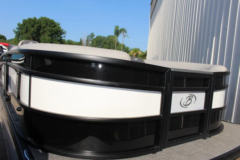 Slide: The Image of 2025 Barletta Lusso 23U pontoon boat, sleek design, docked outdoors. - 2